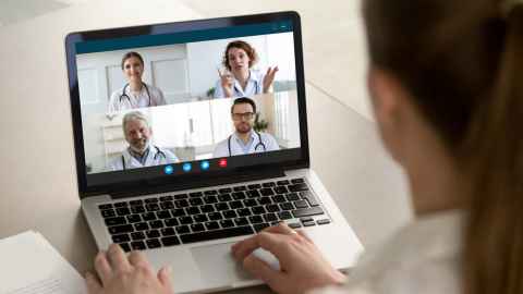 Patient being seen by a team of doctors, online and on a laptop