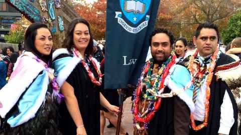 Four Pacific students dressed in Law regalia for graduation.