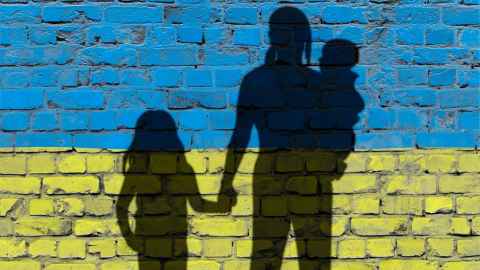 Graphic illustration showing mother and children facing a wall painted in Ukrainian colours yellow and blue