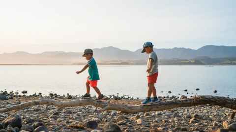 Children walking along foreshore in New Zealand 