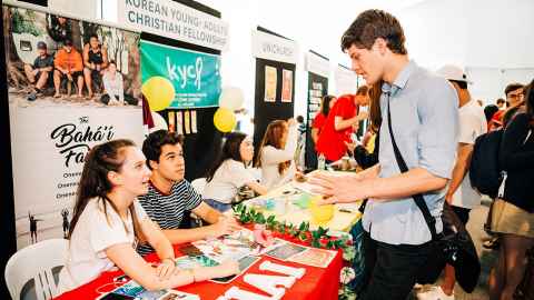 Students talk to each other at a faith and spirituality stall