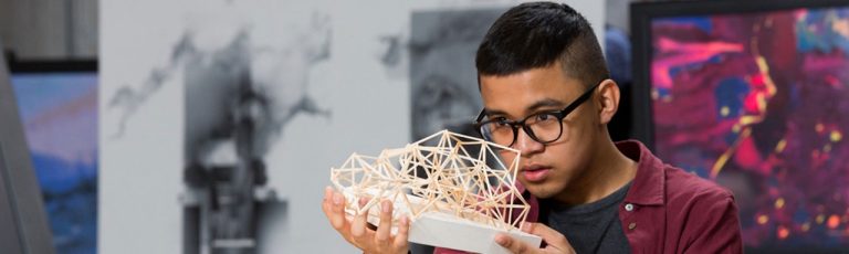 A student looking at a building truss model
