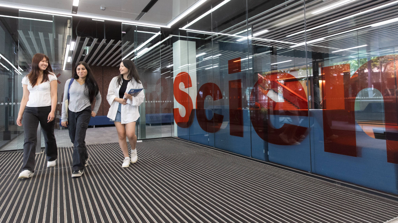 Three students walking inside the Science building.