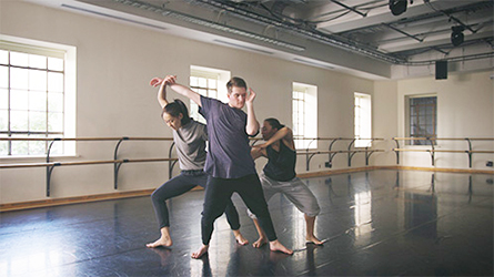 Three students in dance poses