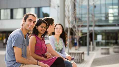 Students sitting outside a University building.