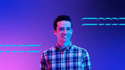Smiling young man standing in front of a purple background