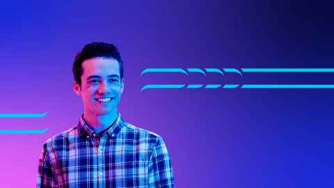 Smiling young man standing in front of a purple background.