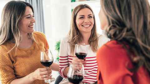 Three women drinking red wine
