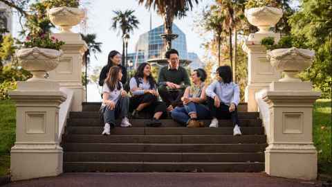 Group of international students sitting on steps in Albert Park