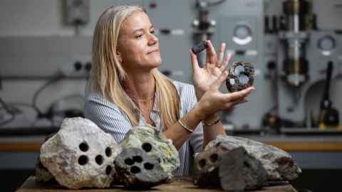 Ludmila Adam inspecting rocks in a lab