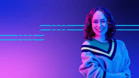 Student standing against a pink and blue background.