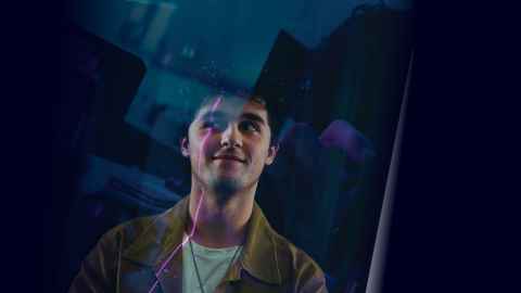 Smiling student standing against blue background.