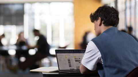 Student working on a laptop in the University Library