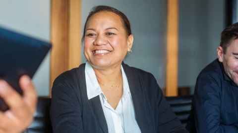 Pacific woman in a meeting smiling