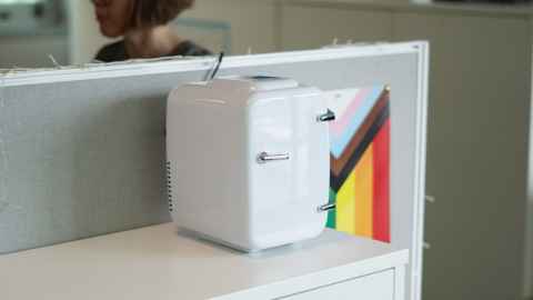 Mini-fridge on desk with Rainbow flag in background