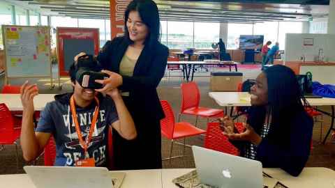 Alumni Anzel Singh, Weilian Du and Sarah Mwashomah demonstrate a virtual reality headset.