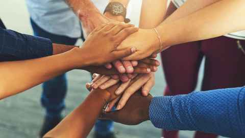 People standing with their hands in a circle