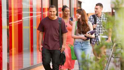 A group of four students walking through the City Campus.