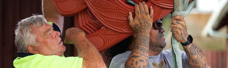 Master carver Arekatera (Katz) Maihi, Ngāti Whātua Ōrākei and Ngāpuhi (right), with Keith Walker (left), builder of Tāne-nui-a-rangi in 1987, together positioning the new maihi on Tāne-nui-a-rangi in 2024.