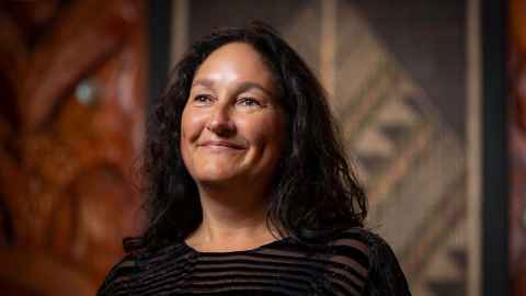 Portrait of Ihonuku Māori, Professor Te Kawehau Hoskins smiling, head tilted back.