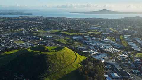 The green cone of Maungārei, Mount Wellington bottom left hand corner, fanning out to industrial buildings, then Rangitoto is in the top right hand corner.