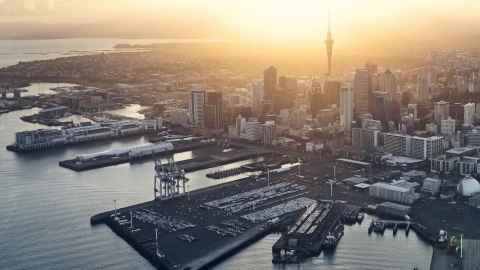 Auckland City at sunset from Auckland Harbour, including the wharves and Sky Tower