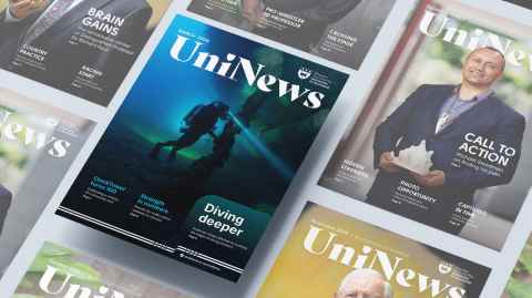 The cover of March UniNews, featuring a wetsuit-clad Professor Simon Mitchell underwater