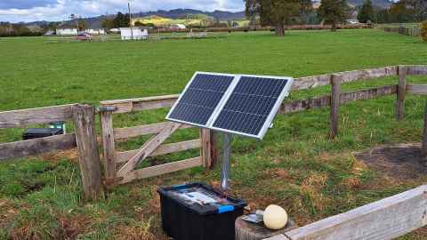 Seismic monitoring at Ardmore Field Station. Seismic-monitoring equipment in the foreground close to a fence and gate, in pastoral land.