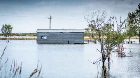 Farm building submerged in floodwaters