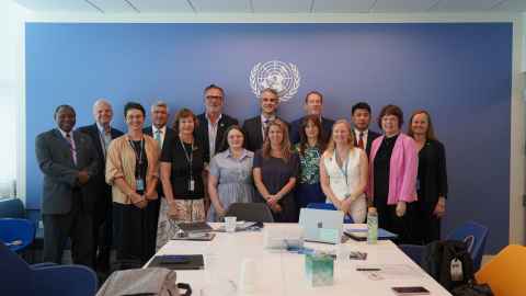 A University delegation of three pictured with others attending a meeting at the United Nations 