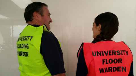Building and floor wardens in high-visibility vests.