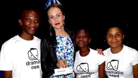 A woman with three young people wearing 'dramatic need' t-shirts.