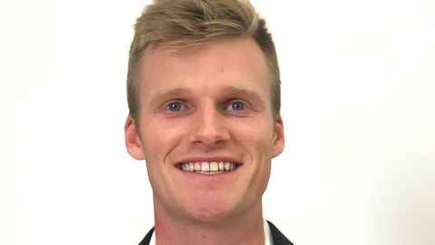 A close-up of a fair-haired young man with blue eyes.