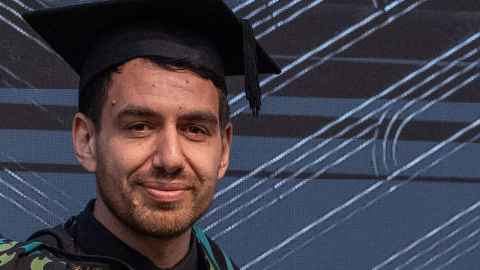 A young man in graduation regalia.
