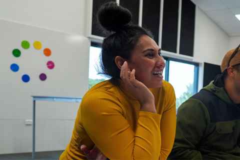 A woman in a yellow top, with her black hair in a bun.