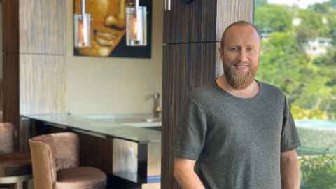 A man with a beard, wearing a grey shirt.