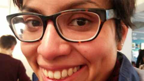 A close-up of a young woman wearing tortoiseshell-rimmed glasses.