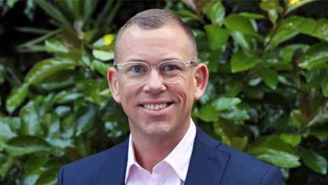 A man with glasses, wearing a business suit.