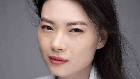 Close-up of an Asian woman in a white top.