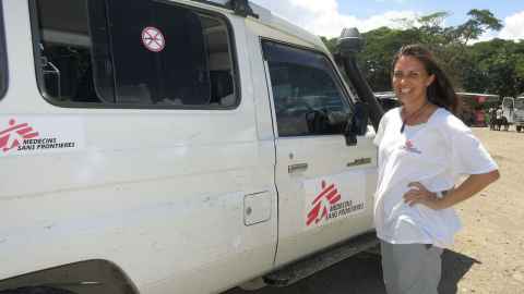 A woman standing next to a van with "Medicines sans Frontieres' written on it.