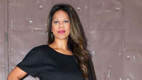 A woman in black, wearing bright pink lipstick.