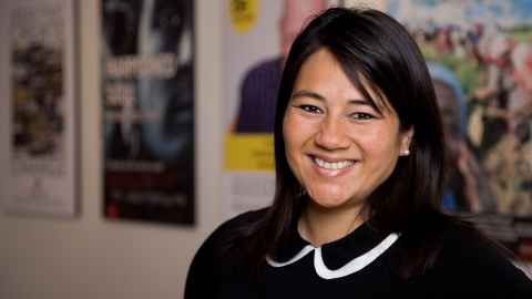 A black-haired woman wearing a black and white top. 