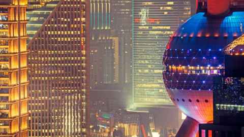 A cluster of brightly-lit tall buildings at night.