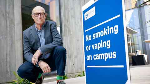 Boyd Swinburn next to a no smoking no vaping sign