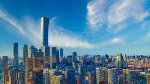 A modern city with one very tall building and a lot of somewhat less tall buildings, on a sunny day.