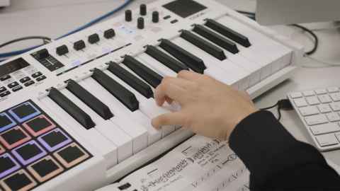 Decorative image of hands playing a midi keyboard