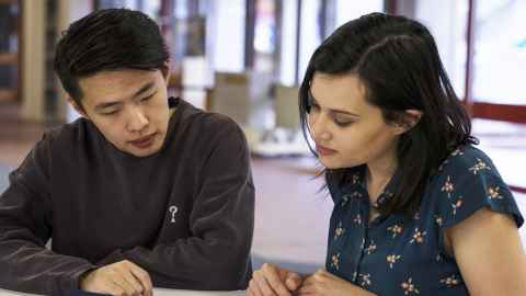 Two people looking at table in front of where they're sitting