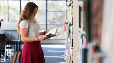 Student reading a book in the General Library