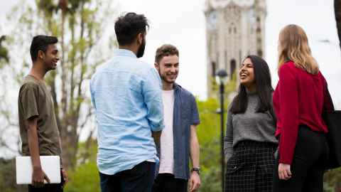 Five students in front of University clock tower