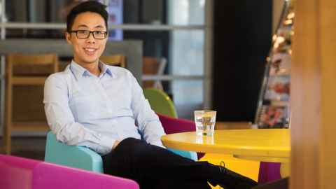 Male student sitting at desk wearing glasses